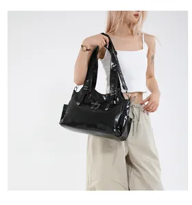 Dettaglio borsa tote in pelle verniciata nera lucida con logo in metallo e tasca