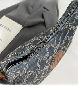 Detailed close-up of smooth metal zipper and denim jacquard fabric on the tote bag