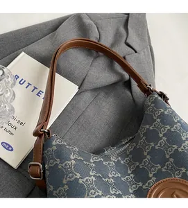 Detail of blue monogram canvas and brown leather trim on a stylish shoulder bag