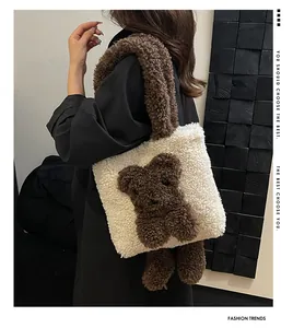 Detailansicht der cremefarbenen Teddy-Tasche mit braunem Plüschbären auf einem Model