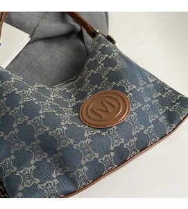 Detailed macro view of retro monogram canvas and brown leather trim with M logo patch