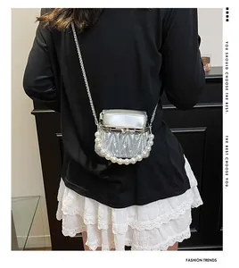 Detail einer silbernen gesteppten Mini-Tasche mit Perlengriff und Metallkette