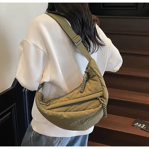 Olive green nylon dumpling bag detail with wide shoulder strap and woven zipper puller