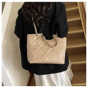 Detailed close-up of beige quilted tote bag with gold chain strap and large capacity