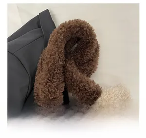 Detail eines breiten Schultergurts aus Lammfellimitat an einer Plüsch-Tasche