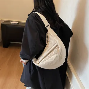 Minimalist beige crescent crossbody bag with wide strap and textured nylon fabric