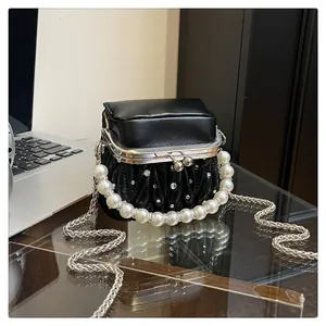 Nahaufnahme der schwarzen Plissee-Lederhandtasche mit Perlengriff und silberner Kette