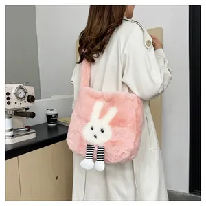Borsa tote in peluche rosa con coniglio indossata da una modella in un caffè