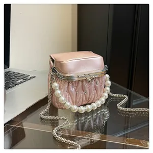 Detail der rosa Falten-Handtasche mit Perlengriff, Metallkette und Strassbesatz