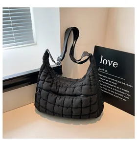 Close-up of black quilted puffer bag with detailed square stitching and metallic zipper