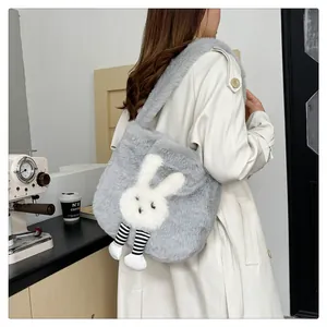 Dettaglio della borsa tote in peluche grigia con design a coniglio e gambe a righe su modella