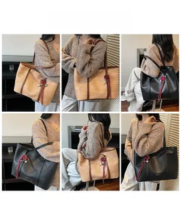 Detail view of large minimalist tote bags in black and brown with woven leather texture