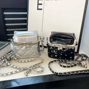 Detail von gesteppten Minitaschen mit Klippverschluss, Metallkette und glitzernden Steinen