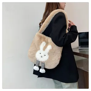 Dettaglio della borsa tote in peluche kaki con motivo a coniglio e ciondolo a righe