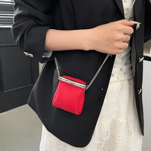 Detailed texture of red pebbled leather lipstick bag with elegant silver chain strap