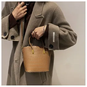 Brown crocodile embossed bucket bag styled with a brown coat for autumn look
