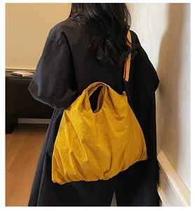 Fashionable large yellow canvas tote bag shown as a shoulder bag on a model back view