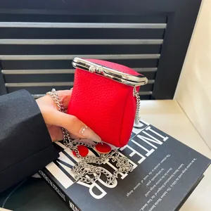 Mini red pebbled leather lipstick bag with silver clasp closure and delicate chain strap