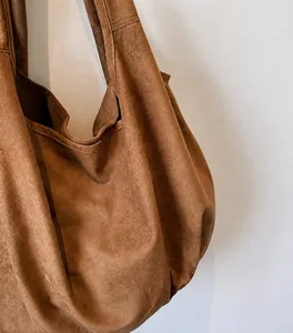 Detailed close-up of soft brown suede tote bag showing premium matte texture and finish
