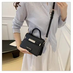 Close-up of black leather texture with gold metal bar and adjustable shoulder strap