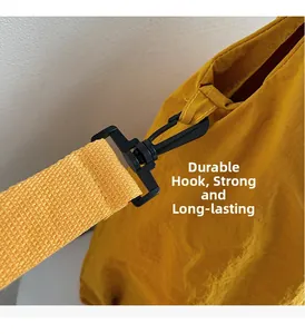 Detail of durable hook and high-density woven strap on yellow canvas shoulder bag