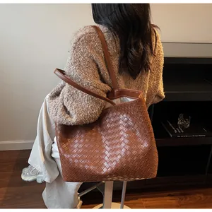 Macro view of dark brown woven leather texture on a spacious tote bag for women