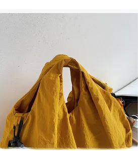 Detail of wide comfortable handle and yellow nylon fabric on a casual shoulder bag