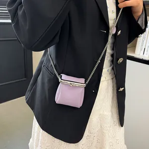 Chic light purple leather mini lipstick bag with metal chain on black suit outfit