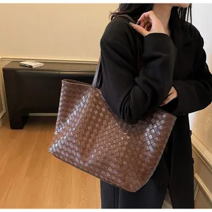 Detail of hand-woven dark brown leather tote bag showing large capacity and weave texture