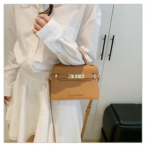 Close-up of khaki leather handbag with gold clasp and Marc Eliza brand logo detail