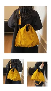 Detail view of yellow nylon tote bag featuring adjustable strap and ruched pleated design