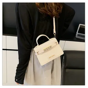 Detail of a creamy white PU leather handbag with a golden lock and MARC ELIZA nameplate