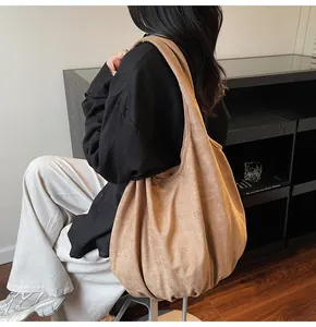 Brown suede tote bag shown on shoulder in a minimalist casual styling outfit