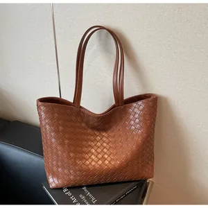 Detail of the high-quality brown leather woven texture on a large capacity tote bag