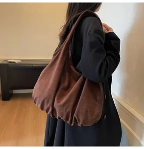 Close-up of a large brown suede tote bag with a soft texture and draped minimalist design