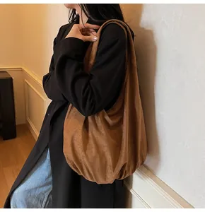 Detail shot of a large caramel brown suede tote bag featuring a soft slouchy design