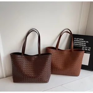 Close-up of woven texture on retro tote bags in dark coffee and caramel brown leather