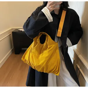 Model wearing a bright yellow large capacity canvas tote bag with adjustable shoulder strap