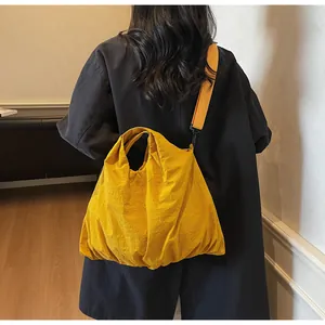 Bright yellow oversized nylon tote bag worn by a model to show capacity and casual style