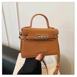 Detail of brown faux leather handbag with scratch-resistant texture and metal buckle