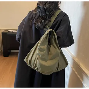Detail of the olive green nylon hobo bag showing adjustable wide shoulder strap and drape