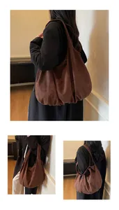Detail of dark brown suede tote bag featuring a slouchy minimalist design and soft texture