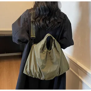 Detail of army green nylon shoulder bag with wide strap and ruched texture design