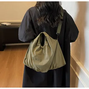 Detailed back view of a large olive green nylon tote bag with a wide adjustable strap