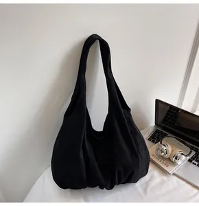 Close-up of a large black tote bag hanging next to office accessories for commute style