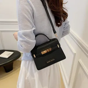 Classic black leather tote bag with gold metal lock and adjustable strap for women