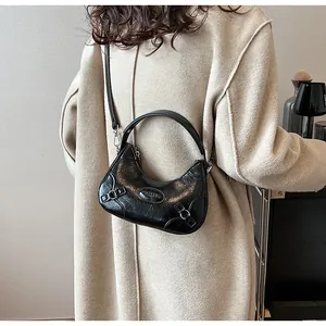 Detail of black crescent handbag with vintage leather texture and silver buckle