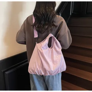 Back view of a lavender lightweight slouchy canvas bag with wide strap on model