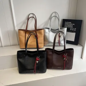 Minimalist large tote bags in black brown beige and silver with heart charms on display