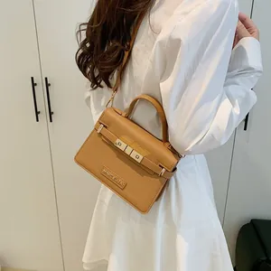 Classic tan leather handbag with gold Marc Eliza logo and adjustable shoulder strap